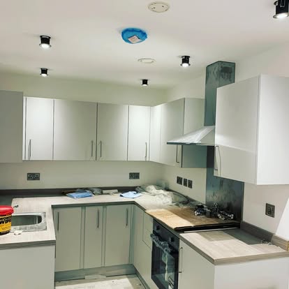 A kitchen with ceiling spotlights and an extractor