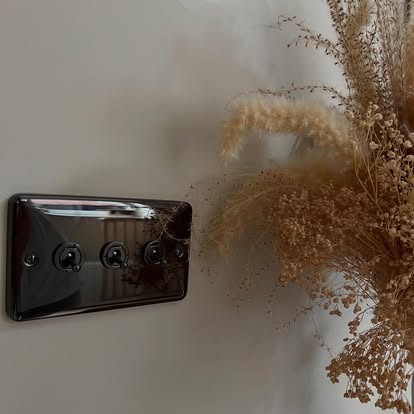 A black nickel three-gang toggle light switch