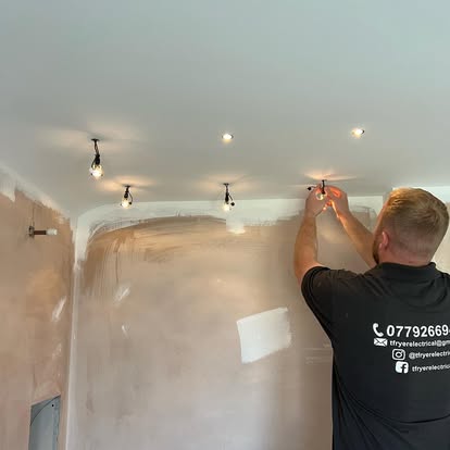 Tom Fryer fitting downlights into a ceiling